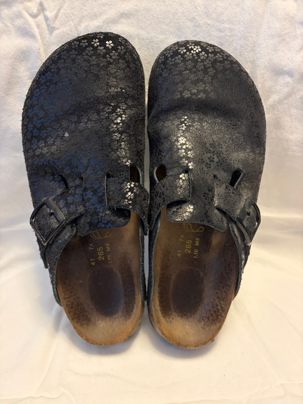 Papillio black suede clogs with embossed flower motif.
